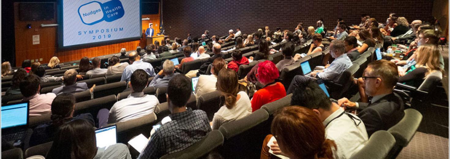 Attendees of the 2019 Nudge Unit Symposium gather in an auditorium