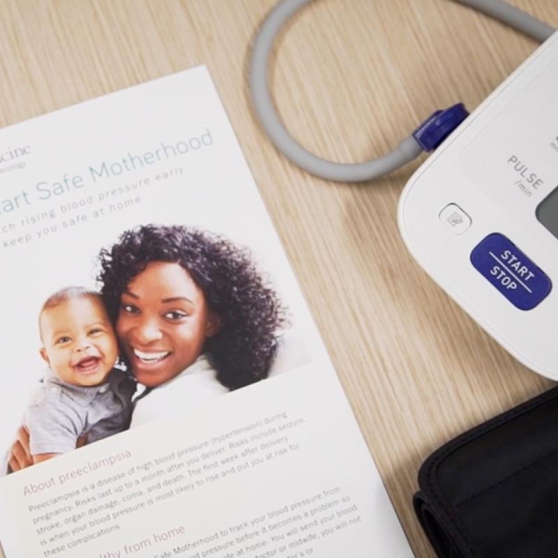 Blood pressure monitor and Heart Safe Motherhood flyer on a desk