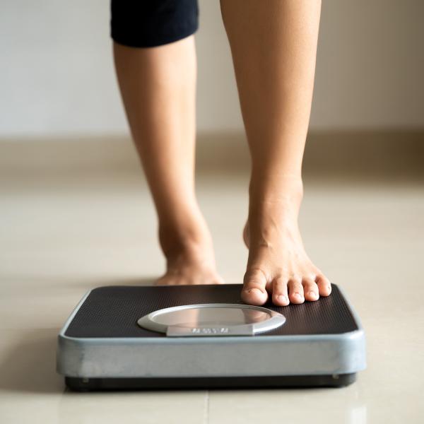 Below-the-knee shot of person stepping on a scale